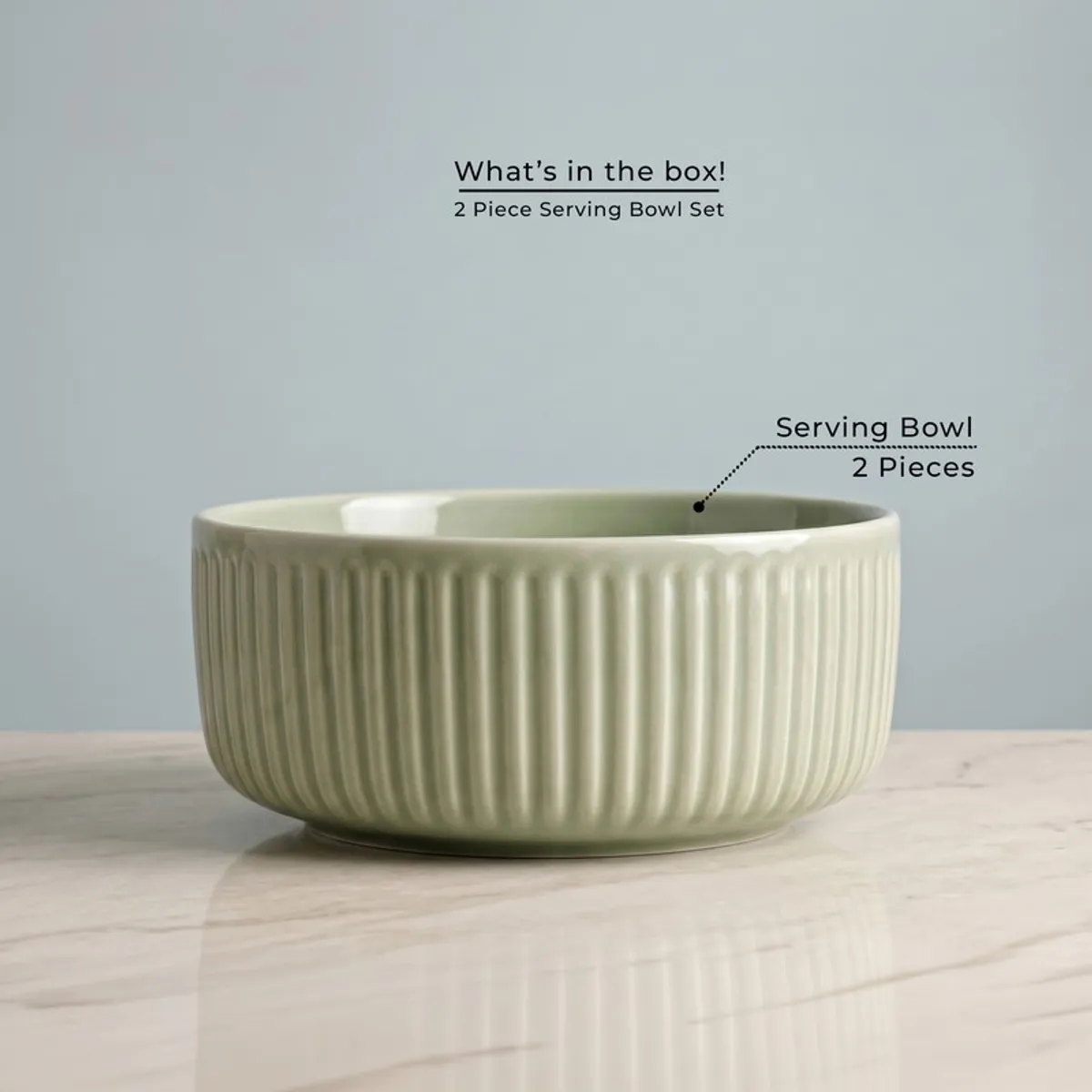 Single sage green ribbed round serving bowl on a tabletop