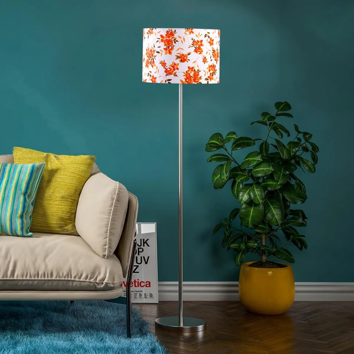 Floral shade floor lamp in a room with a teal wall, sofa and potted plant