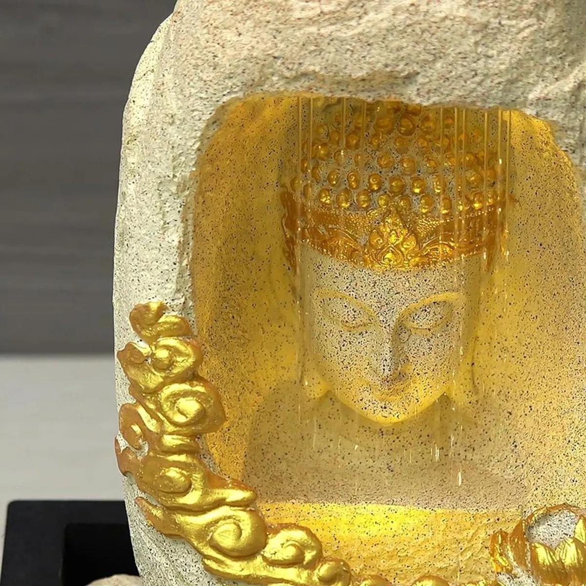 Close-up of the Buddha face and gold cloud detail inside the fountain