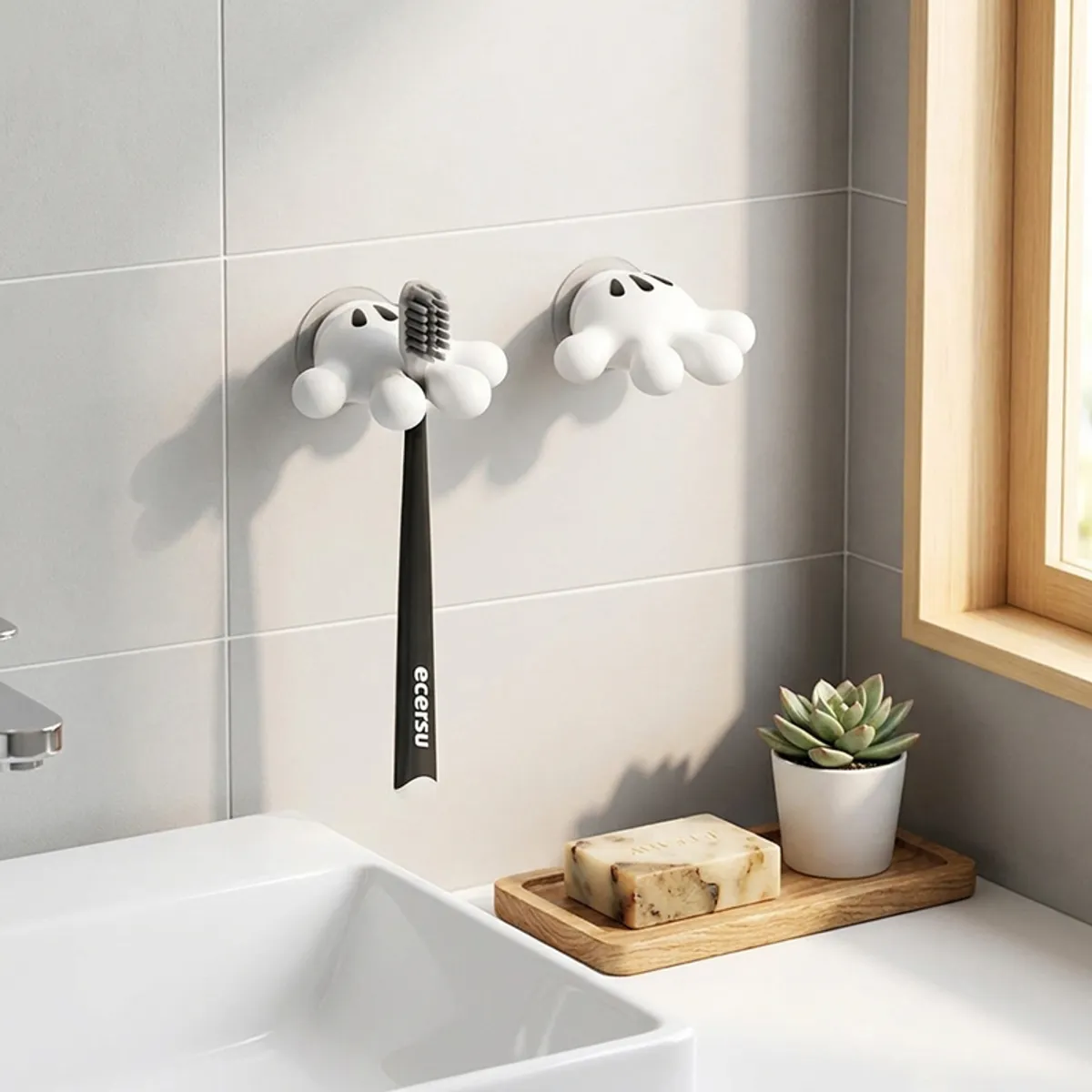 Pair of white suction wall hooks mounted above a bathroom sink