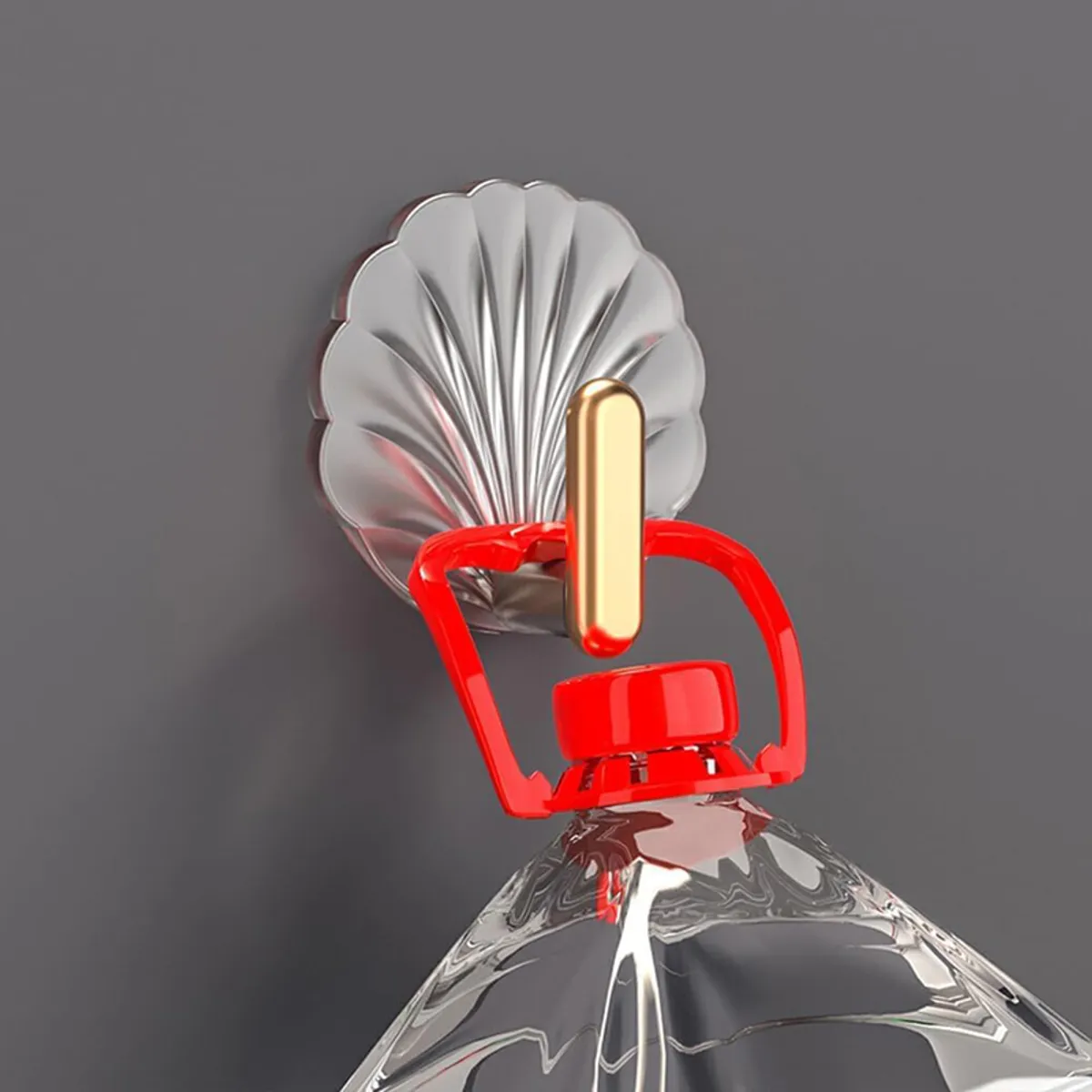 Close-up of a shell-shaped wall hook holding a red bottle handle