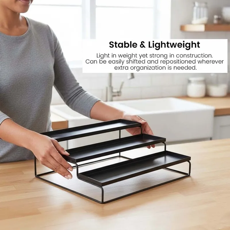 Person holding a black tiered metal organiser over a kitchen counter.