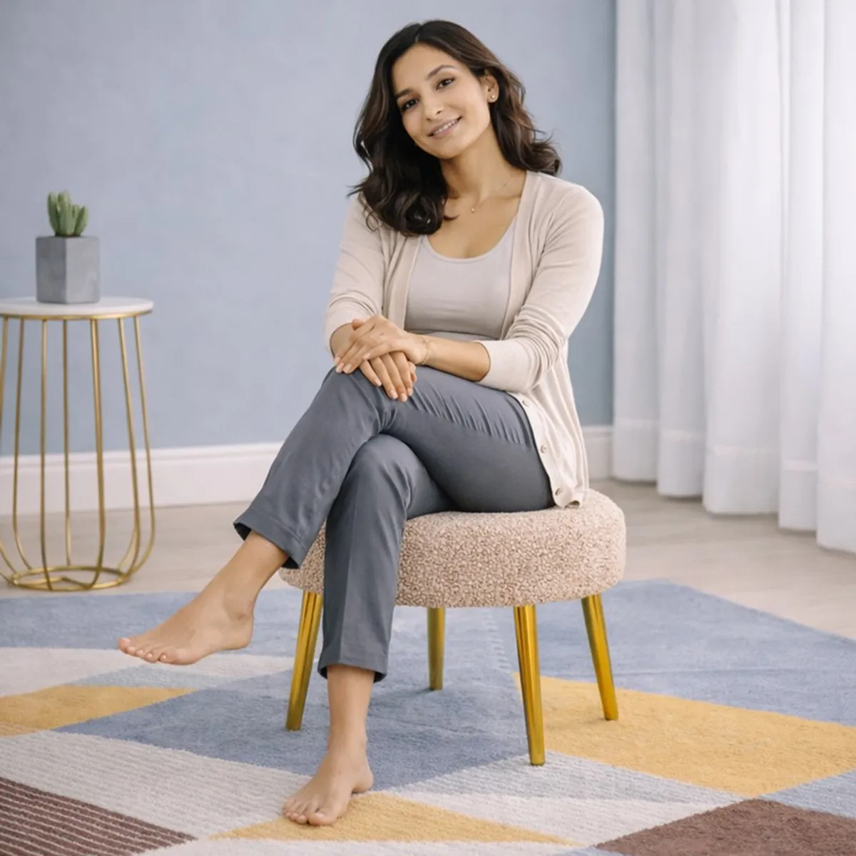 Person seated on a round beige boucle stool with gold legs
