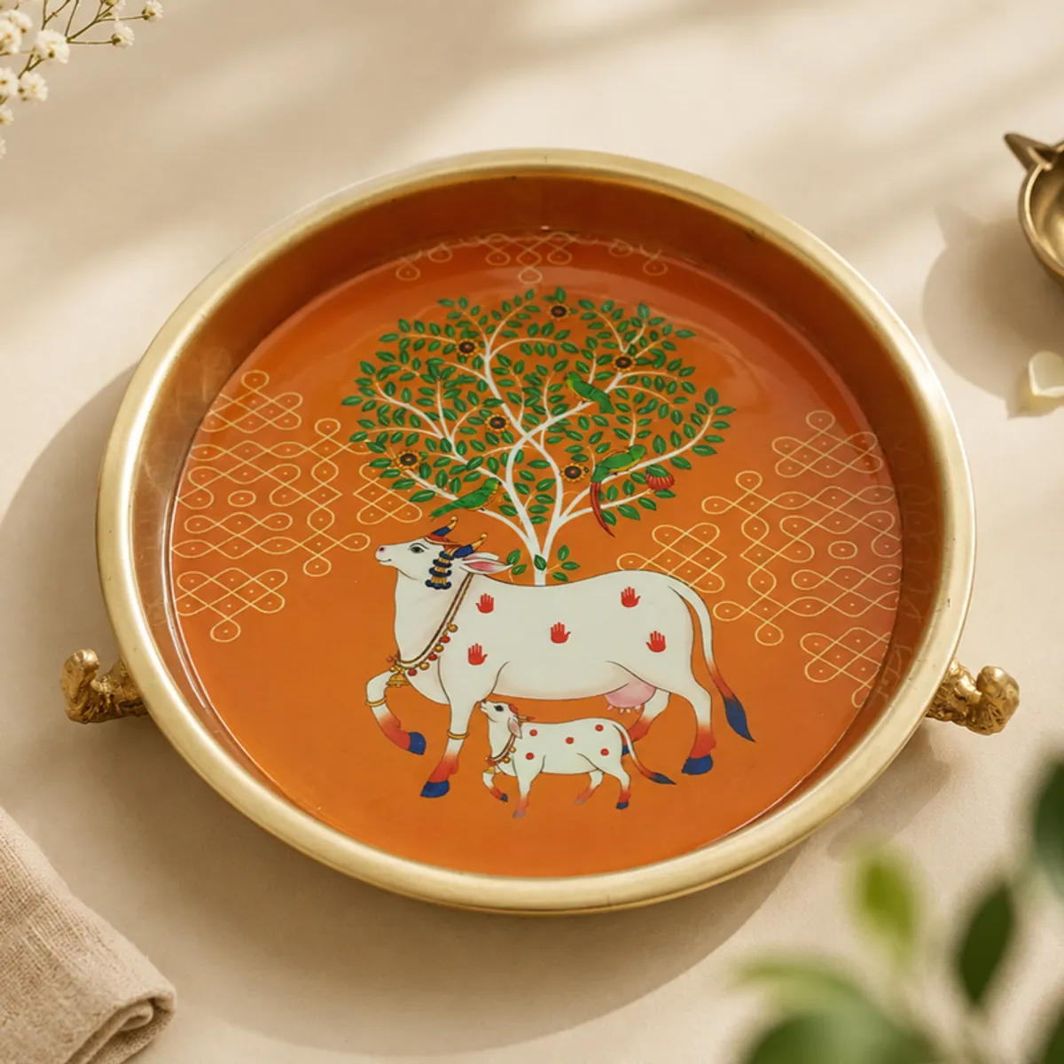 Close overhead view of the orange Kamdhenu and Tree of Life urli