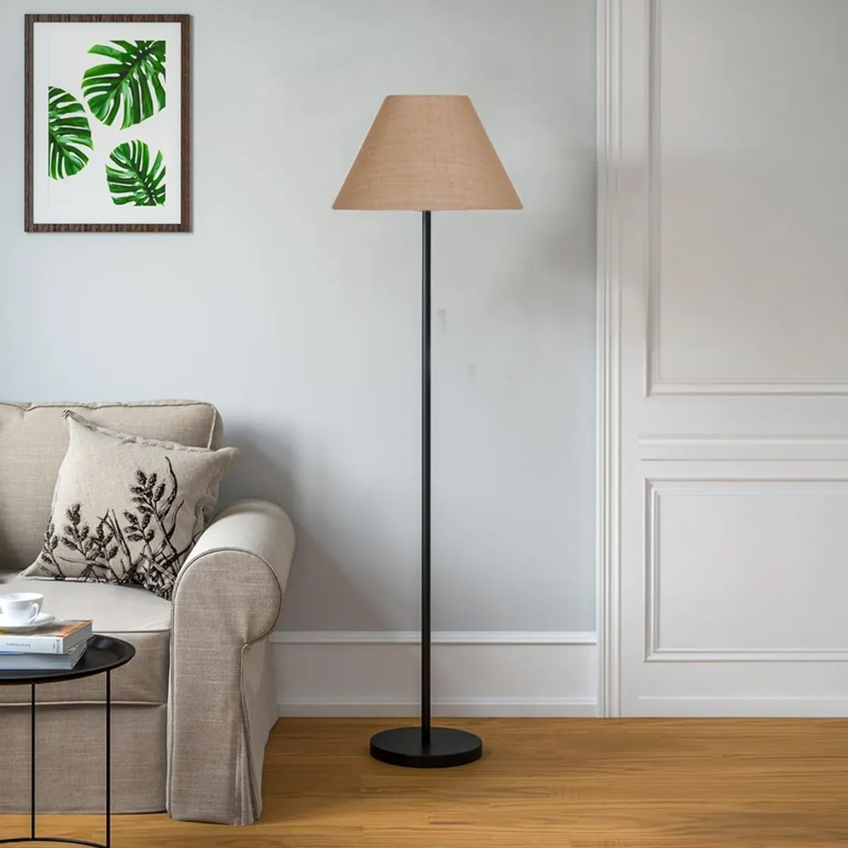 Tapered beige floor lamp with slim black stand in a bright living room corner