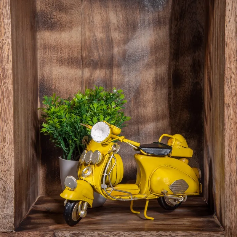 Yellow scooter showpiece displayed inside a wooden shelf