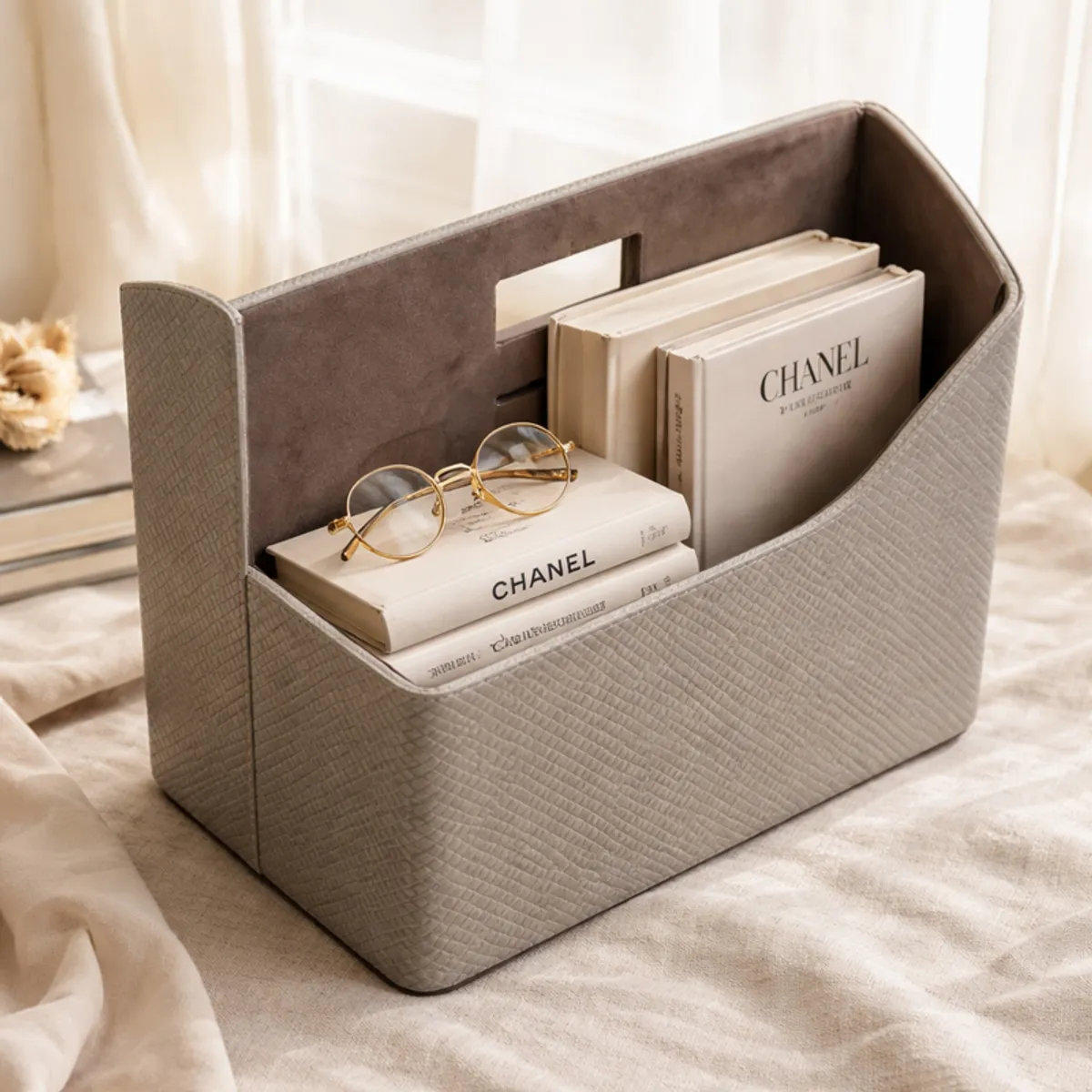 Grey textured organiser holding books and glasses in a softly styled room