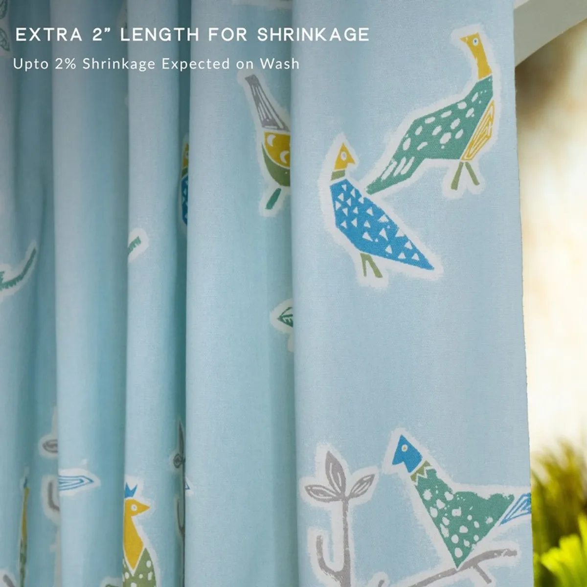 Close-up of light blue curtain showing bird print and soft fabric texture