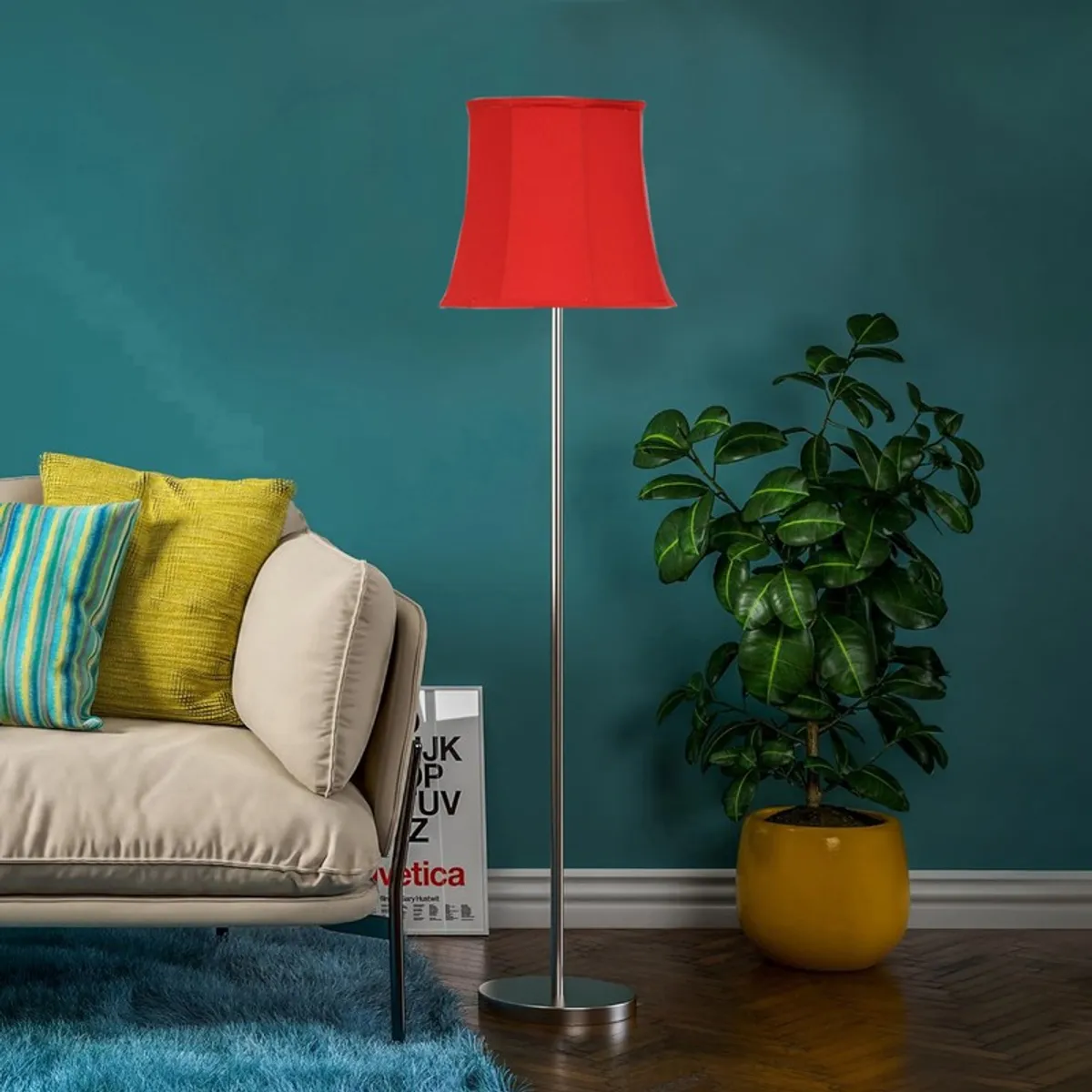 Red floor lamp with silver base in a room with teal wall, sofa and potted plant