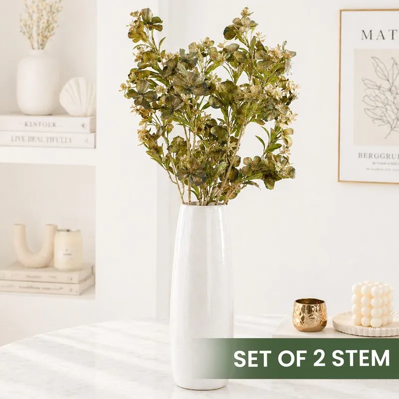 Set of artificial flower stems displayed in a tall white vase