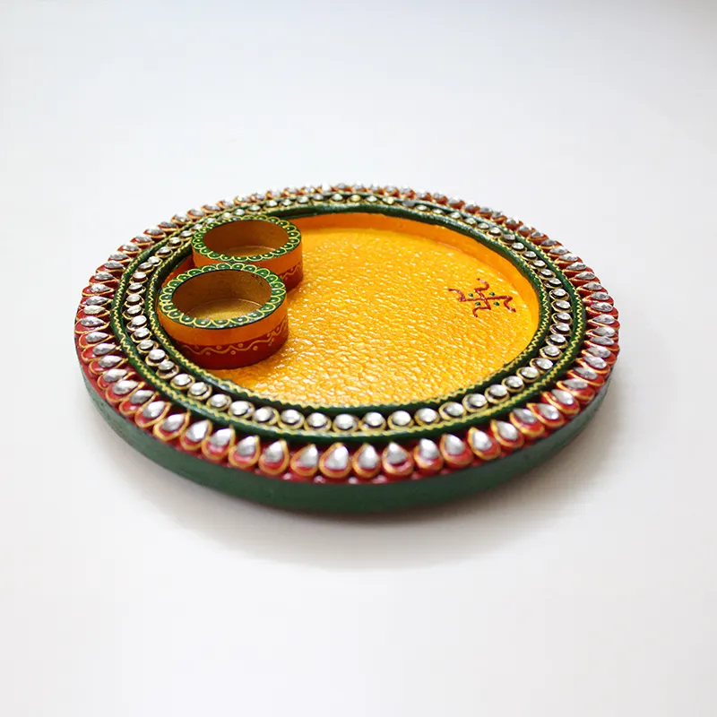 Angled view of the yellow pooja thali with two bowls and embellished border