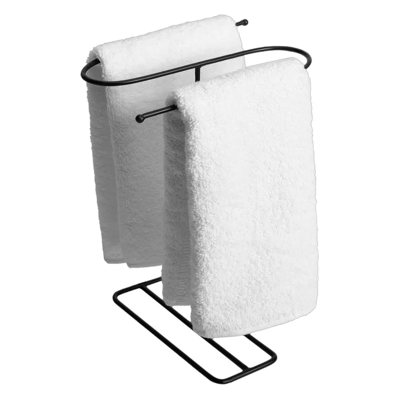 Angled view of the black iron towel hanger holding two white towels