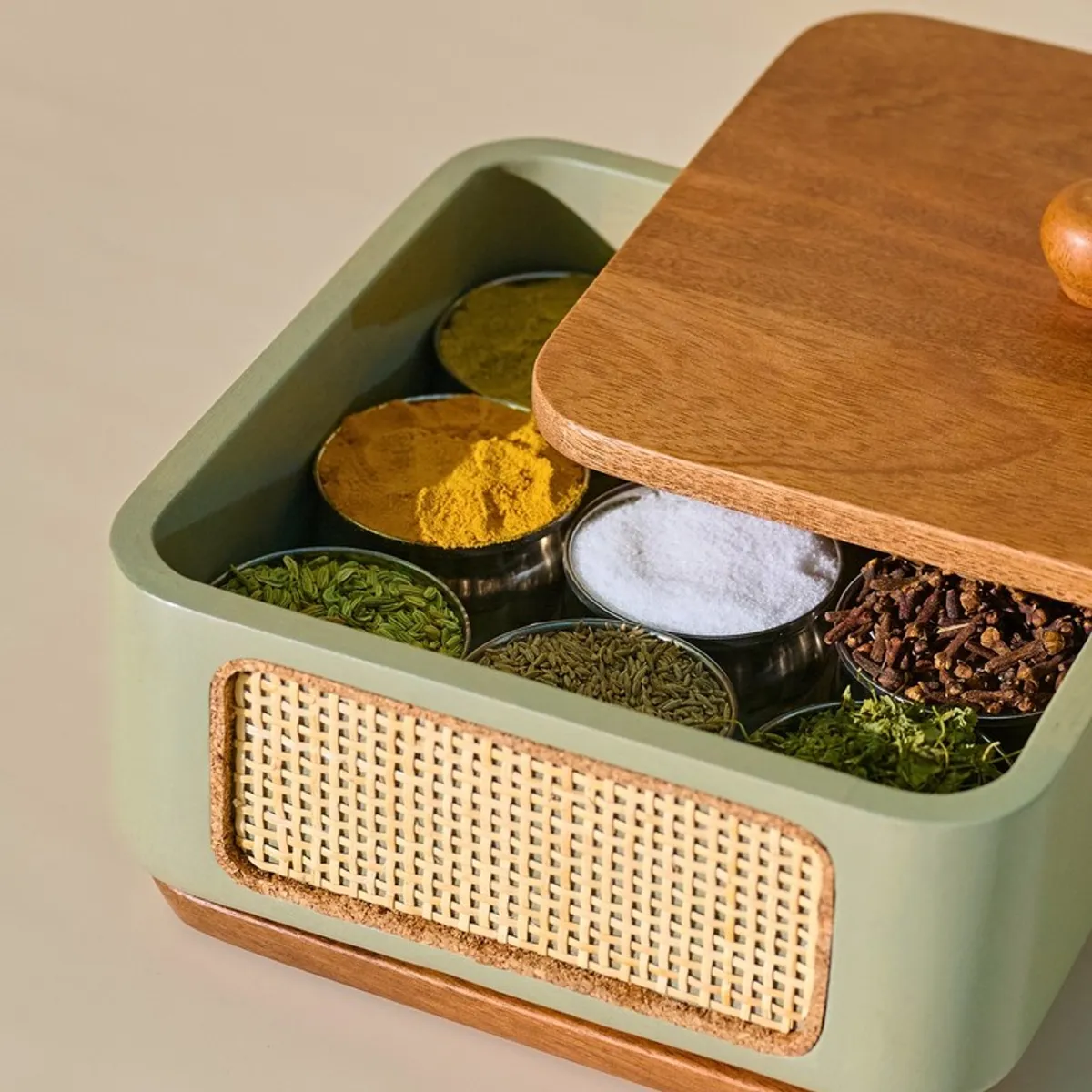 Open masala box filled with colourful spices beneath its wood lid