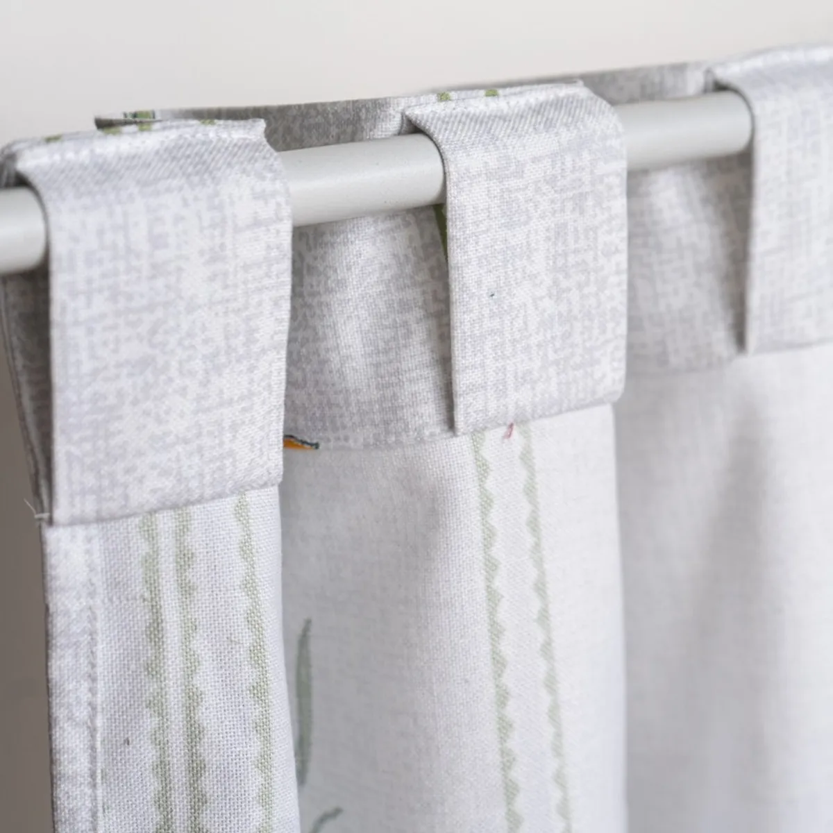 Close-up of back-tab loops on a white floral curtain