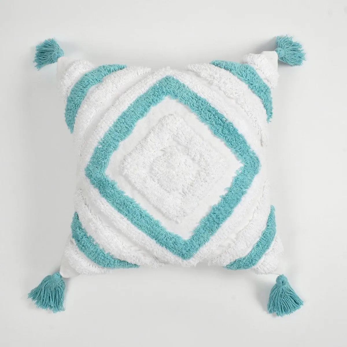 Front view of a white cushion cover with blue diamond pattern and four tassels