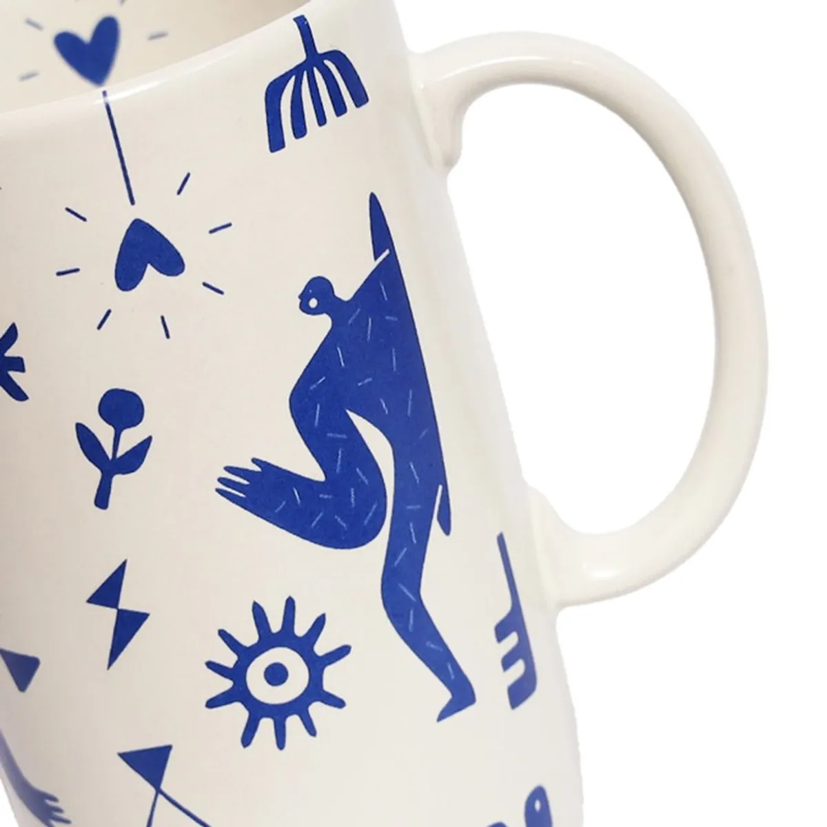 Close-up of mug handle and blue graphic artwork on white surface