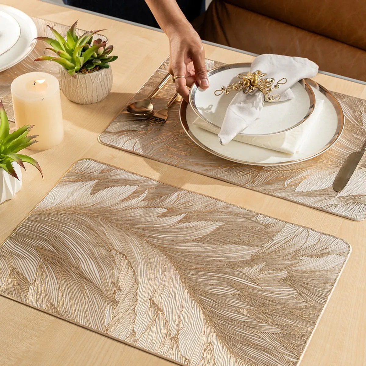 Feather-pattern table mats styled with plates and cutlery on a dining table