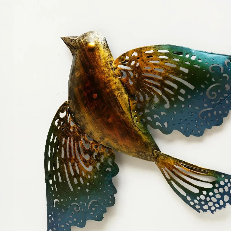 Close-up of a multicolour metal bird wall accent with cutwork wings