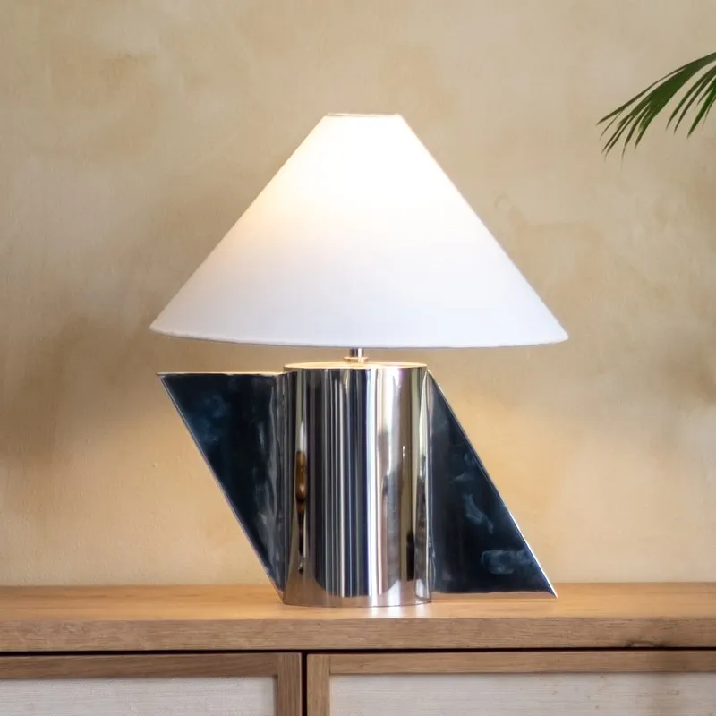Front view of geometric chrome-toned table lamp with white shade