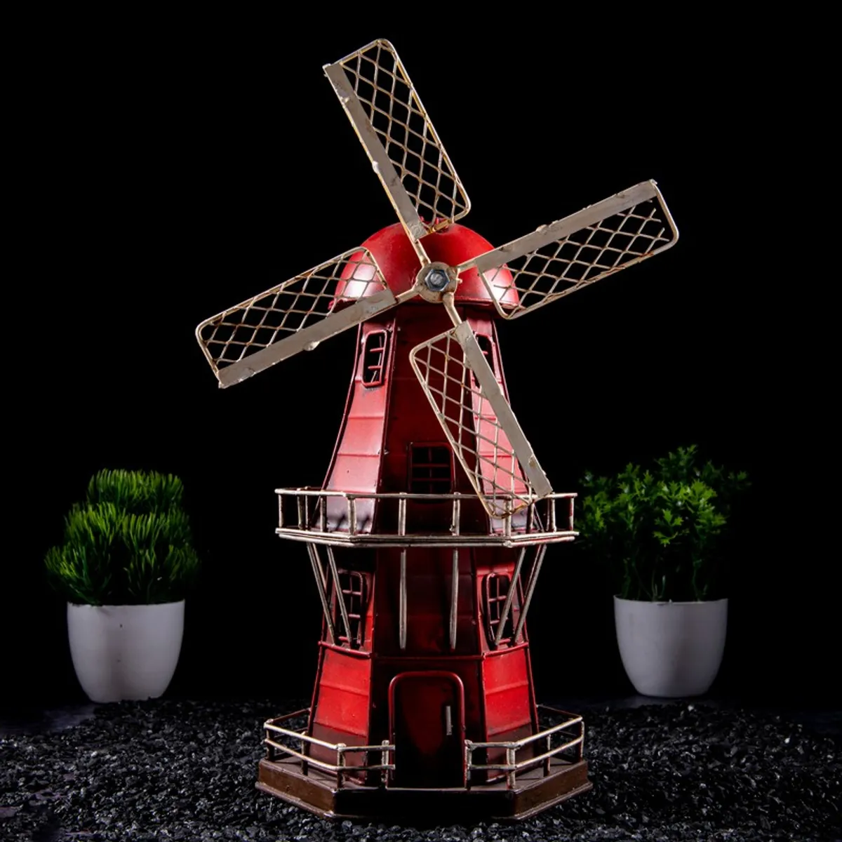 Front view of a red windmill showpiece with metal blades