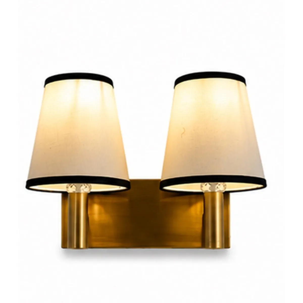 Close front view of twin cotton shades and a gold-toned wall lamp base