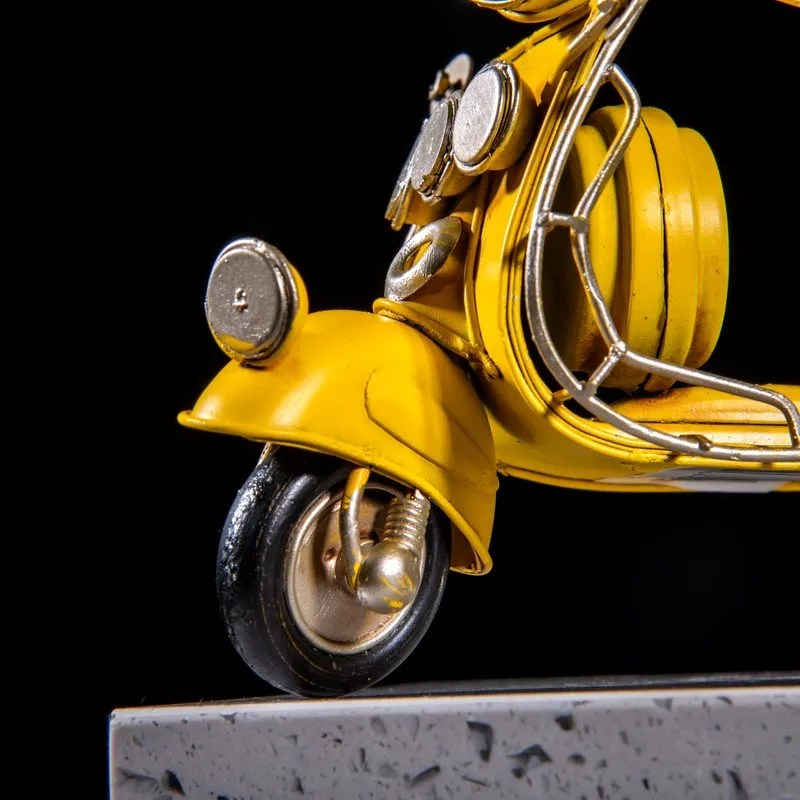 Close-up of front wheel and body of yellow scooter showpiece