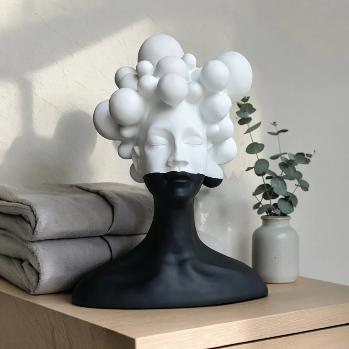 Black and white bubble bust decor displayed on a wooden cabinet