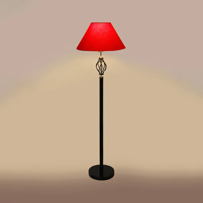 Red shade floor lamp lit against a beige background
