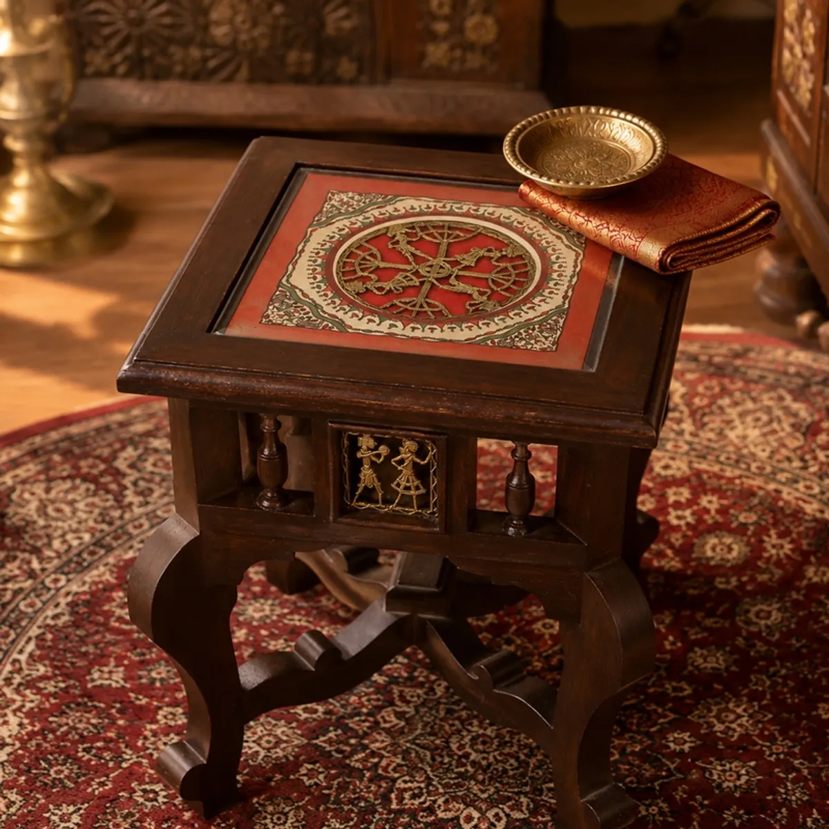 Brown side table with curved legs and a red patterned tabletop insert.