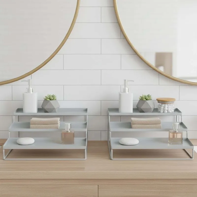 Pair of white stepped metal organisers styled on a vanity beneath round mirrors