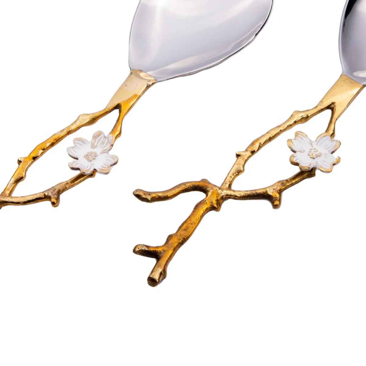 Close-up of gold vine handles and white flower details on two salad servers.