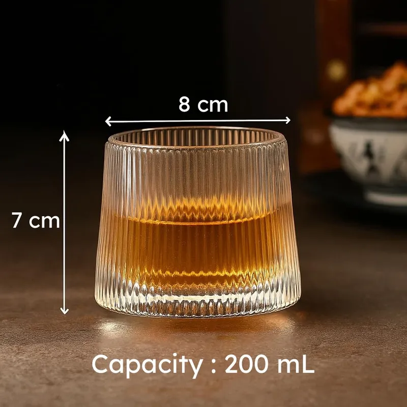 Clear ribbed whiskey glass with amber drink shown with size markings