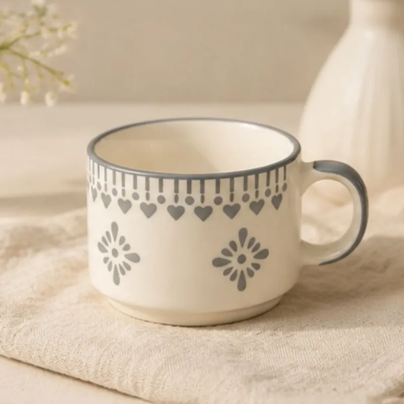 Single white ceramic tea cup with blue floral heart design