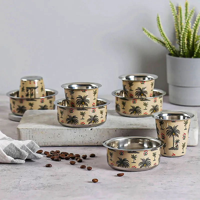 Ivory and silver steel Katori and Tumbler set with palm tree motifs displayed on a table.