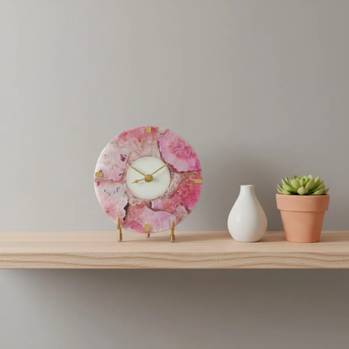 Small round rose agate table clock on a shelf beside a vase and potted plant