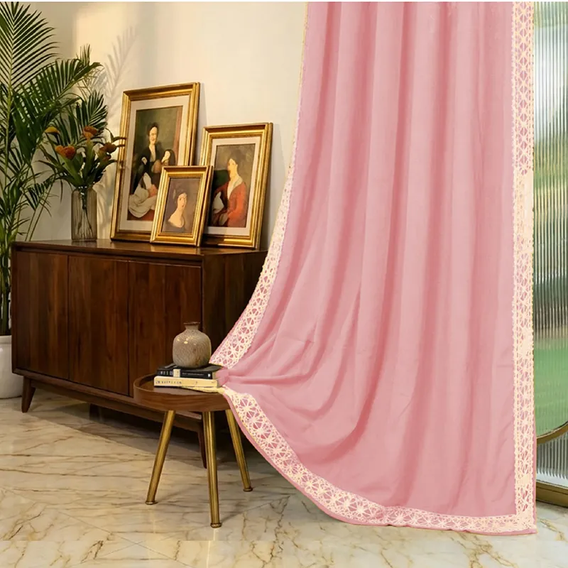 Pink curtain with cream lace border draped beside a wooden console