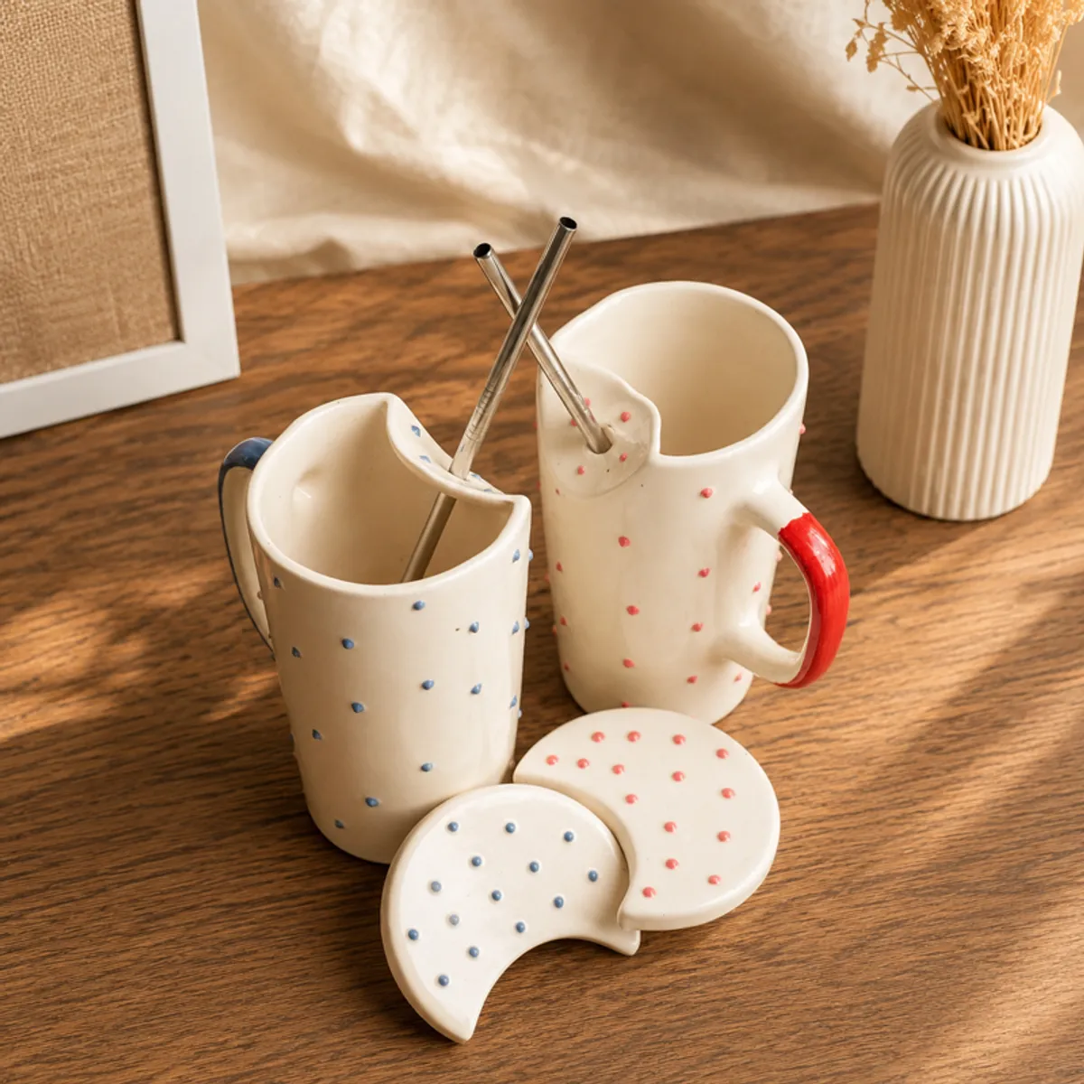 Close view of two dotted ceramic sippers and matching lids