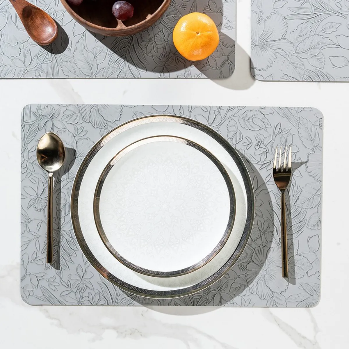 Grey rectangular floral table mat with plate, spoon and fork