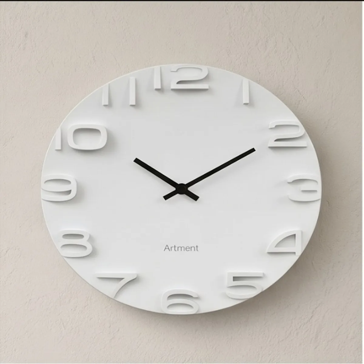 Close-up of white clock face with raised numerals and contrasting black hands