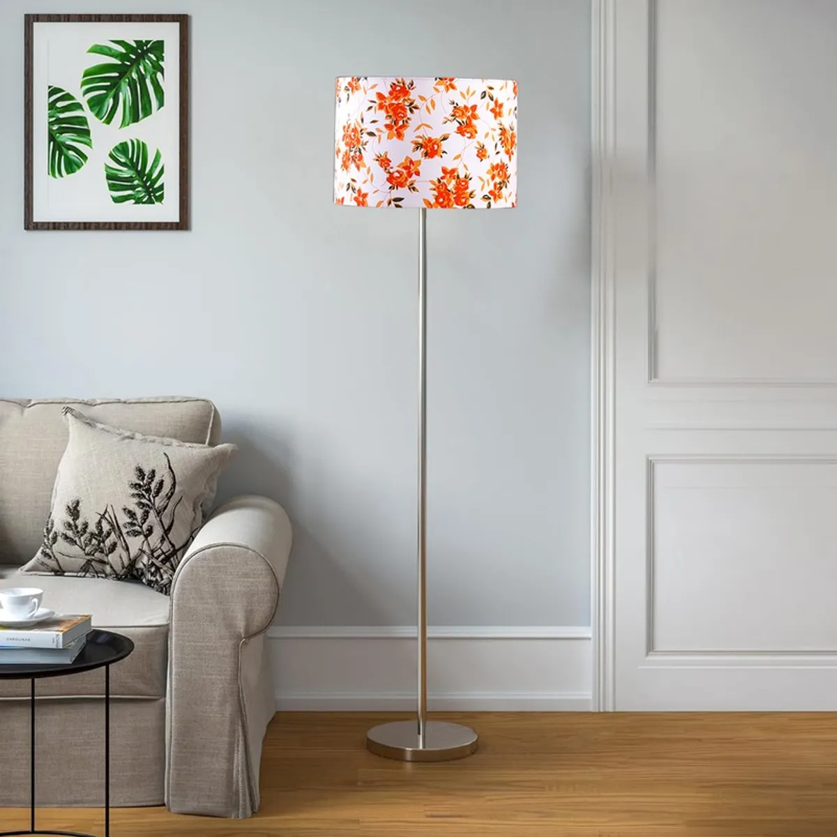 Floral shade floor lamp beside a light grey sofa against a pale wall