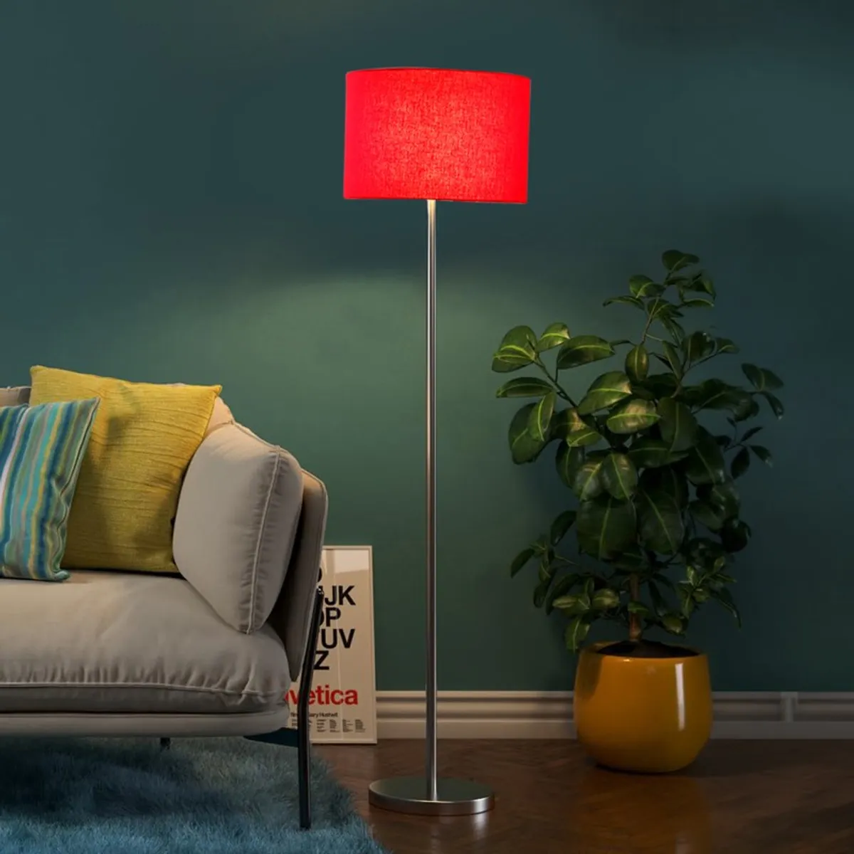 Red shade floor lamp beside a sofa and potted plant in a moody room