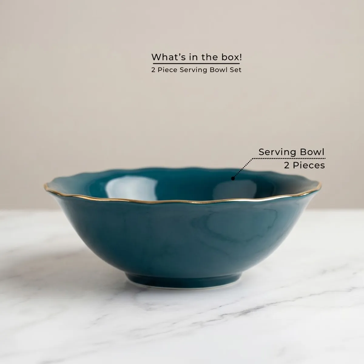 Single dark teal serving bowl with gold rim on a marble-look surface