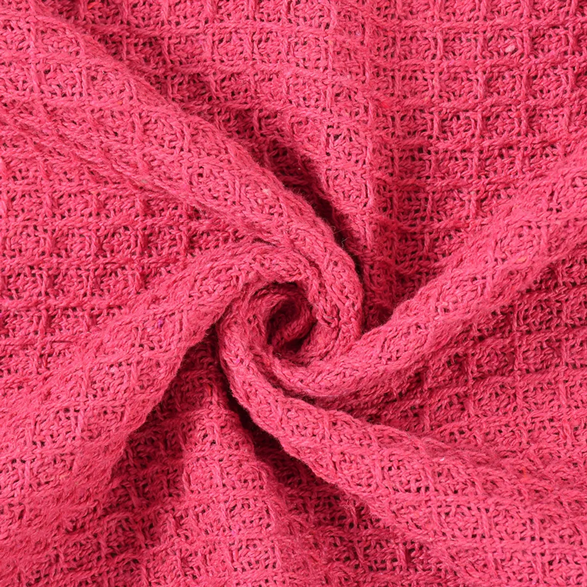 Close-up of bright pink waffle-textured throw fabric