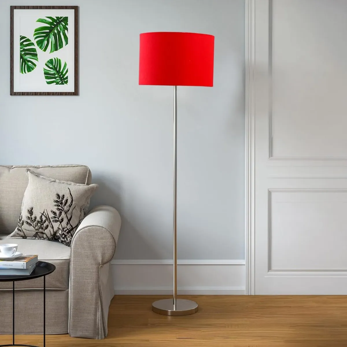 Red shade floor lamp in a bright living room beside a sofa and side table
