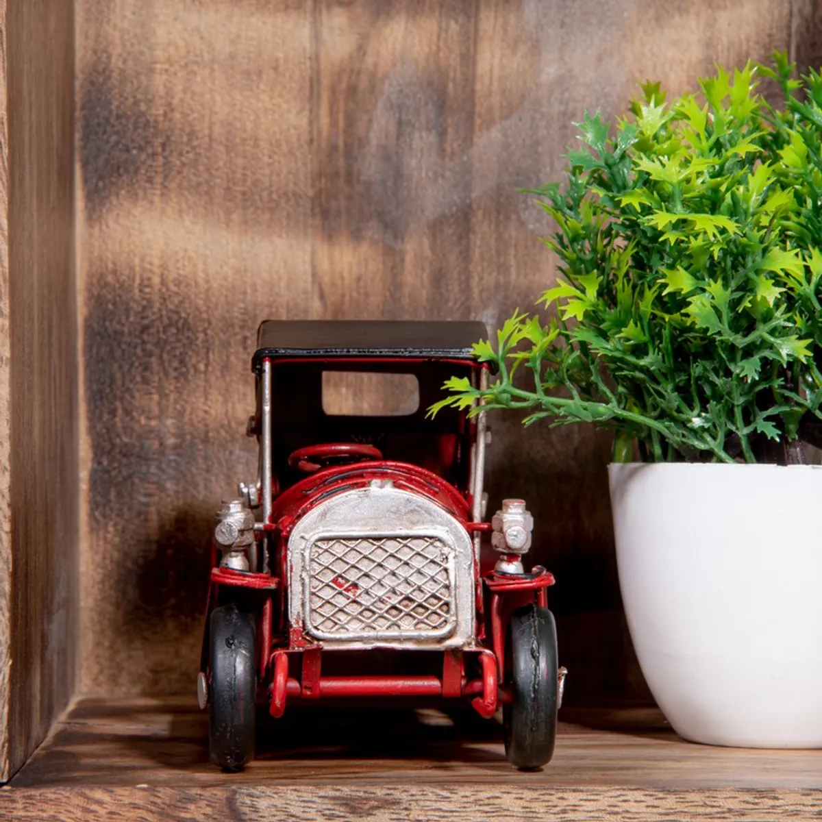 Front view of red vintage car showpiece on a shelf
