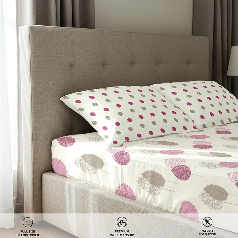 Close-up of fitted sheet and pillow covers with pink polka dot and botanical prints