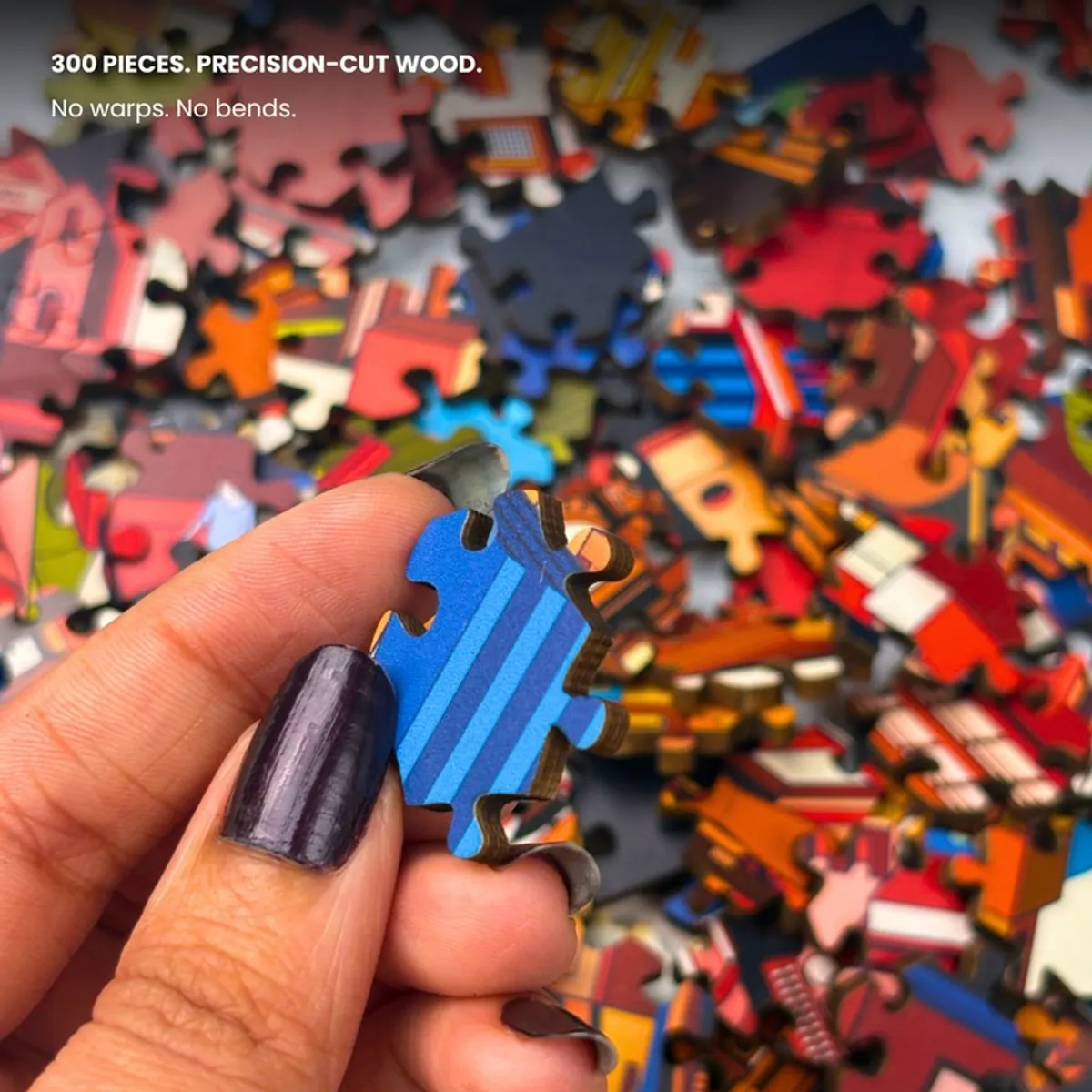 Close-up of a blue puzzle piece held in hand with other pieces blurred behind