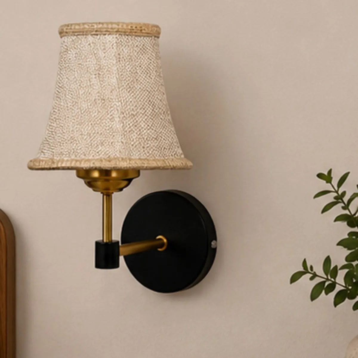 Front view of beige jute wall lamp with round black metal wall plate