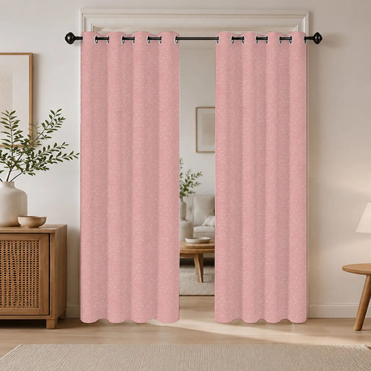Two pink patterned eyelet curtains hanging on a black curtain rod