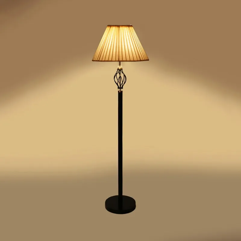 Pleated floor lamp switched on with soft light spread on a beige background